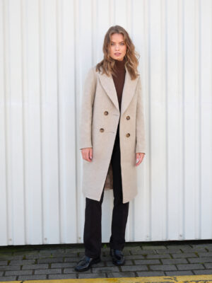 Ocieplany taliowany płaszcz do kolan z miękkiego materiału wełnianego. Bazowe kolory, klasyczny krój. Zgrabny i klasyczny fason.