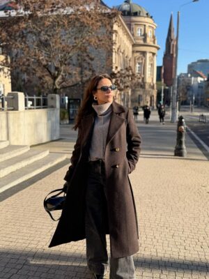 Długi zimowy płaszcz o klasycznym ponadczasowym kroju. Uszyty w wełny dziewiczej w jodełkę czekoladowo-czarną.