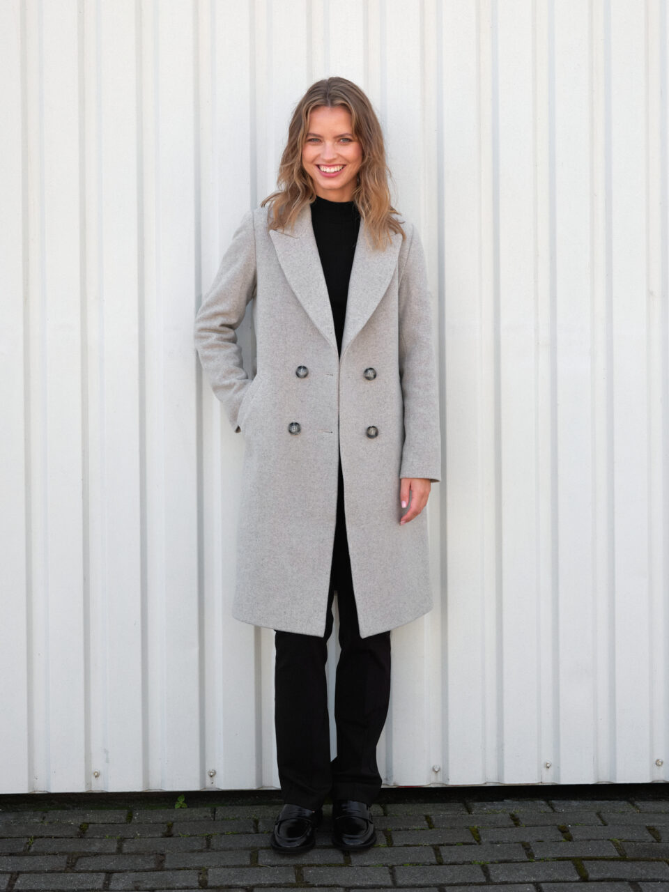 Klasyczny płaszcz w nowoczesnym wydaniu. Szlachetny materiał w szaro-beżową jodełkę średniej długości. Idealny dla niskich osób.