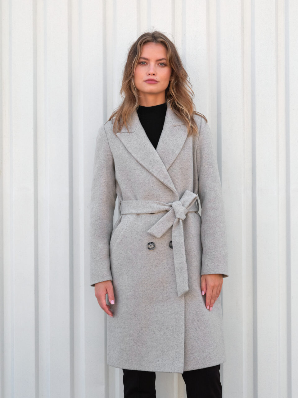 Wełniany płaszcz średniej długości w jodełkę. Dopasowany krój. Wiązany. Nowoczesna klasyka.