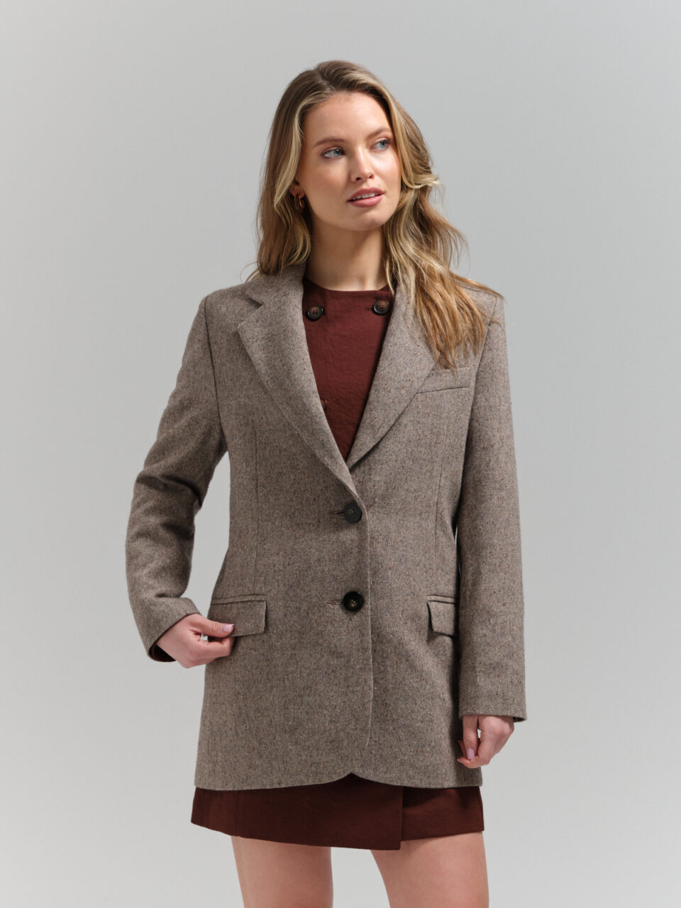 Tweedowy blazer jednorzędowy zapinany na guziki w ciekawym nakrapianym materiale. Nowoczesny, swobodny krój.