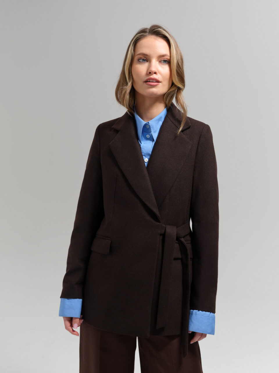 Czekoladowy blezer jednorzędowy z mieszanki wełny. Dopasowany krój finezyjnie wiązany z boku.
