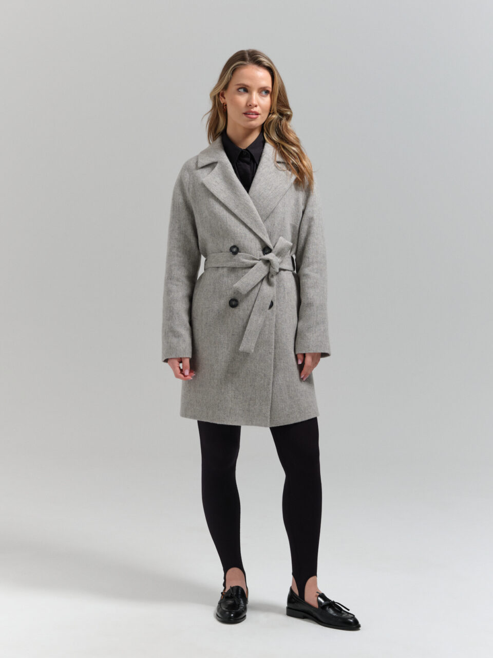 Szary płaszczyk przejściowy o minimalistycznym kroju i wygodnej długości do połowy uda. Szlachetny materiał. Jakość premium.