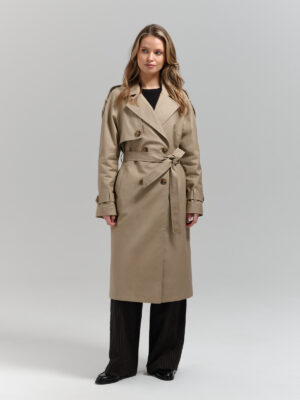 Długi ponadczasowy trencz damski w beżowym kolorze. Uszyty z grubej, mięsistej bawełny. Ikoniczny model.