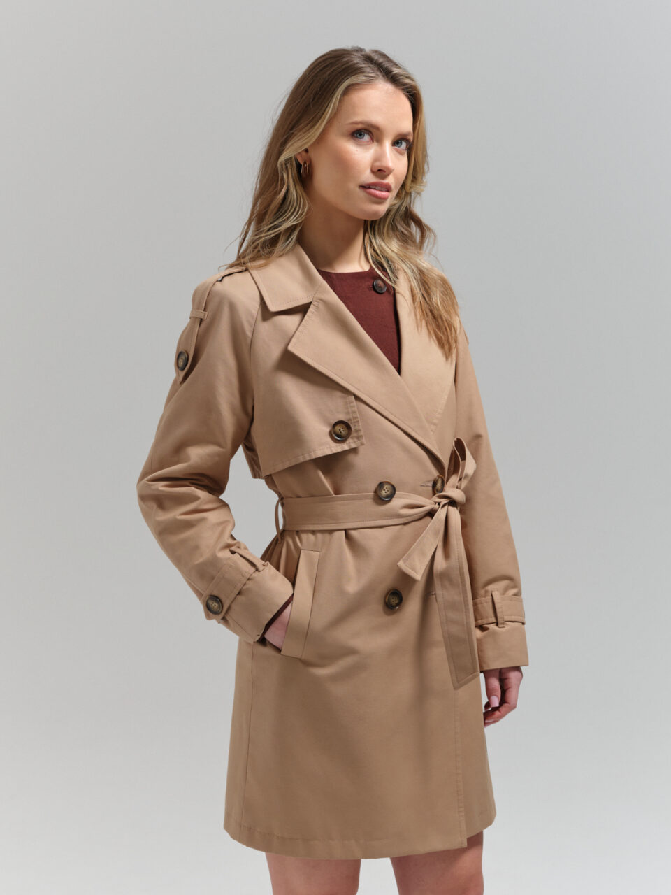 Krótki, beżowy trencz damski z bawełny hydrofobowej. Stylowy i funkcjonalny. Świetna alternatywa dżinsowej katany czy bomberki.