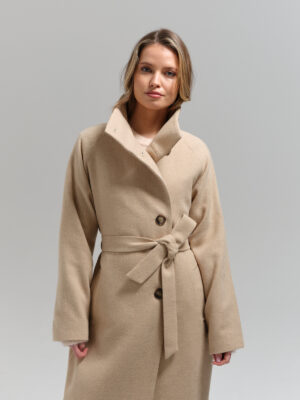 Długi przejściowy płaszcz o pudełkowym kroju z ozdobną peleryną na tyle. Kołnierz podpinany w stójkę.