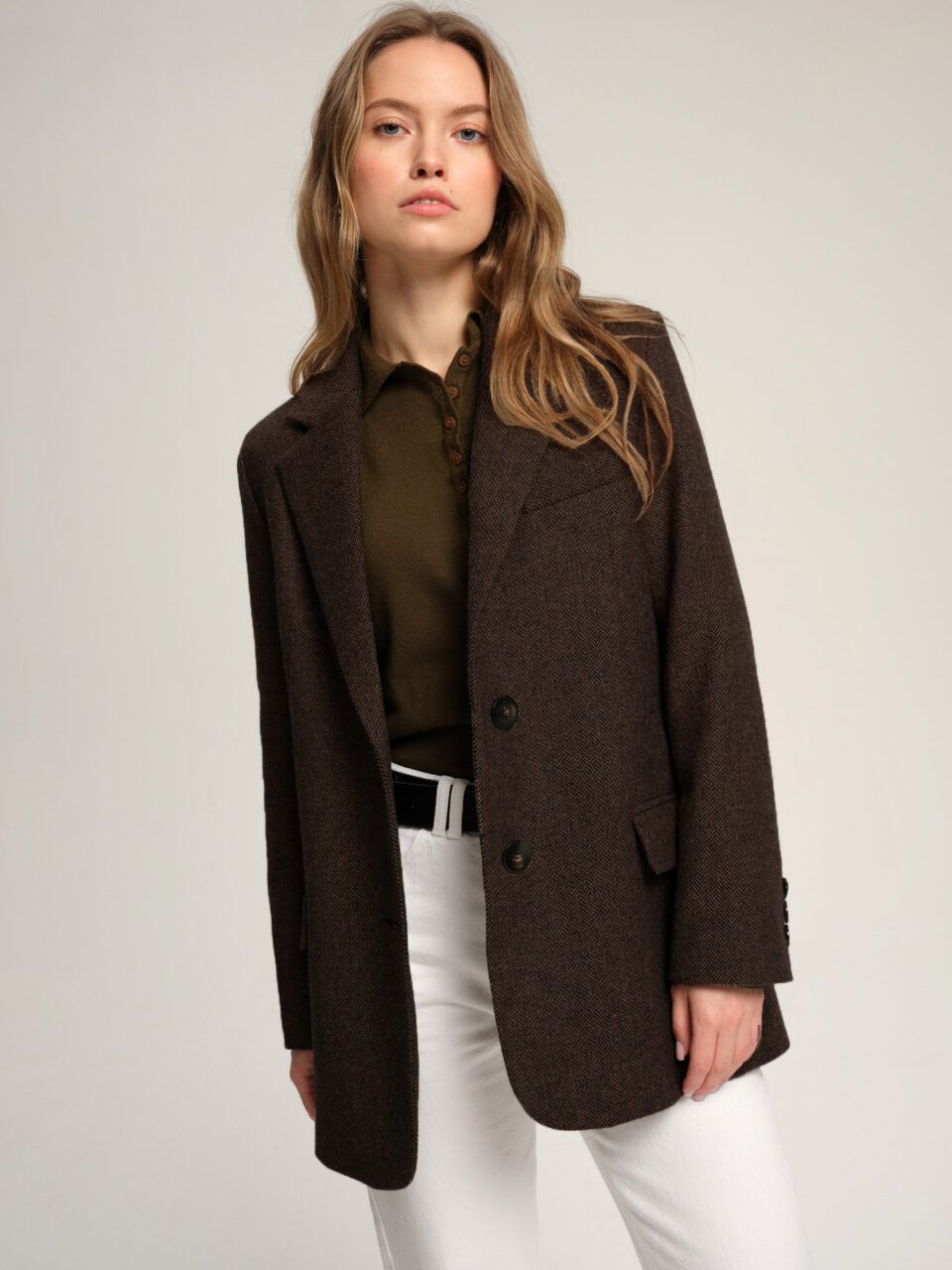 Wełniana tweedowa marynarka damska w męskim stylu. Uniwersalny krój, ponadczasowy wzór w jodełkę i bazowy kolor.